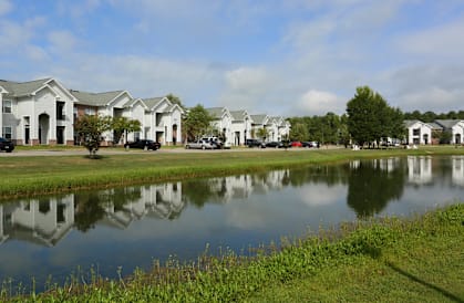 A row of houses are reflected in the water.