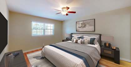 A bedroom with a large bed and a ceiling fan.