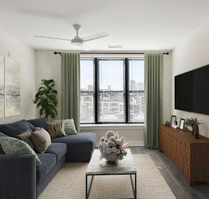 A living room with a blue couch and a flat screen TV mounted on the wall.