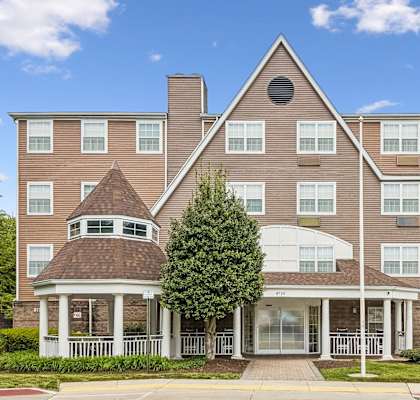 A large apartment complex with a gazebo-like structure in the front.