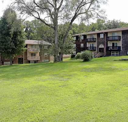 A grassy field in front of apartment buildings.