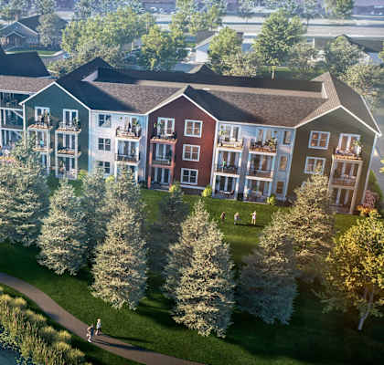 an aerial view of a building next to a body of water and trees