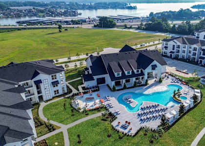 an aerial view of a large swimming pool in front of a house