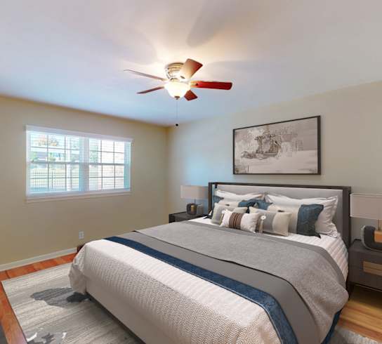 A bedroom with a large bed and a ceiling fan.