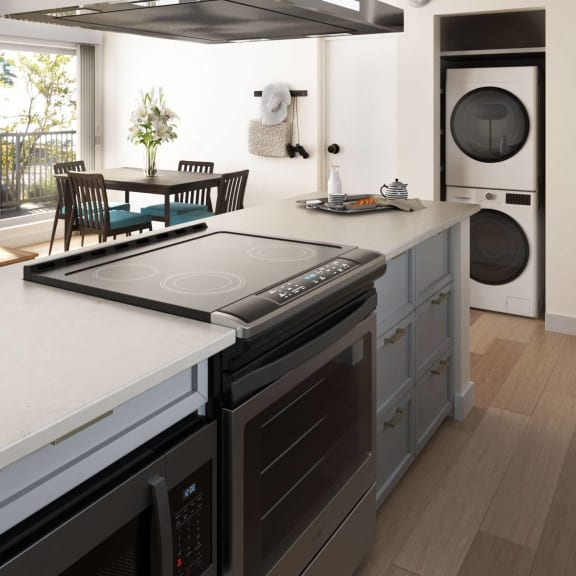 A modern kitchen with a large island and stainless steel appliances at Ocean Edge @ Laguna Beach Apartments, Laguna Beach, CA