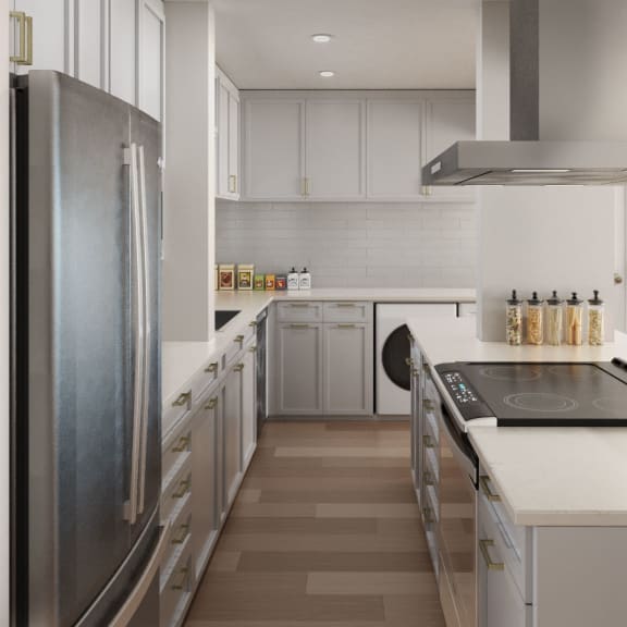 A modern kitchen with a refrigerator on the left and a stove top oven on the right at Ocean Edge @ Laguna Beach Apartments, California, 92651