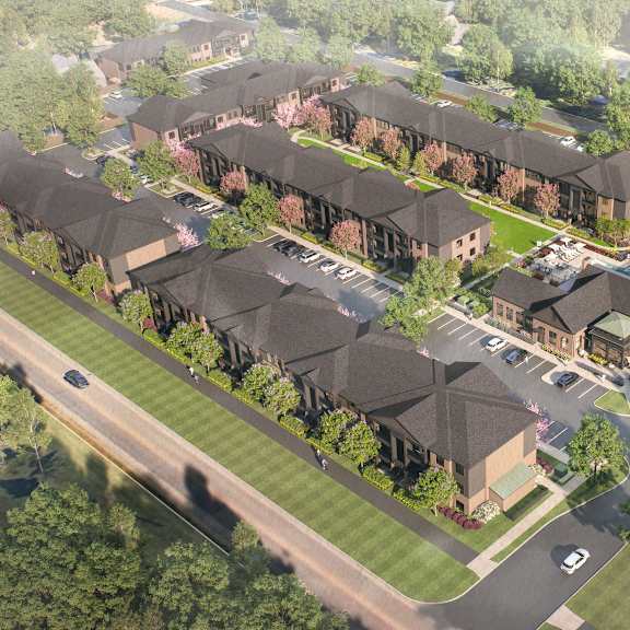 A bird's eye view of a residential area with houses and a parking lot.