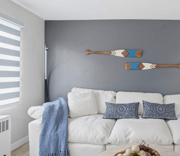 A white couch with a blue throw blanket on it.
