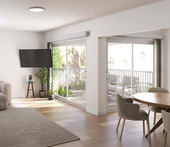 a living room with a couch and a table and a balcony at Ocean Edge @ Laguna Beach Apartments, Laguna Beach