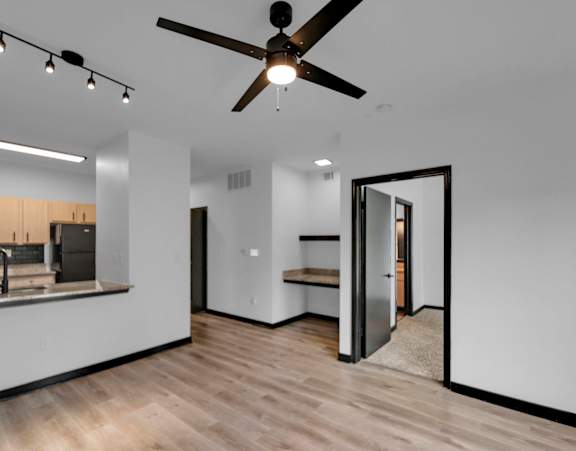 a kitchen with granite countertops and wooden cabinets with a living room in the background at Bristol On Union Apartment Homes, Memphis, Tennessee