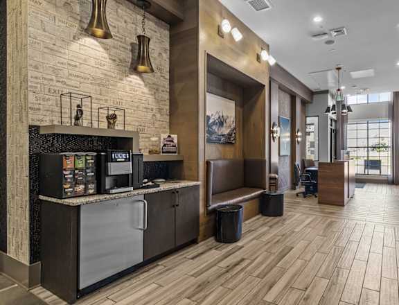 A modern kitchen with a wooden floor and a brick wall.