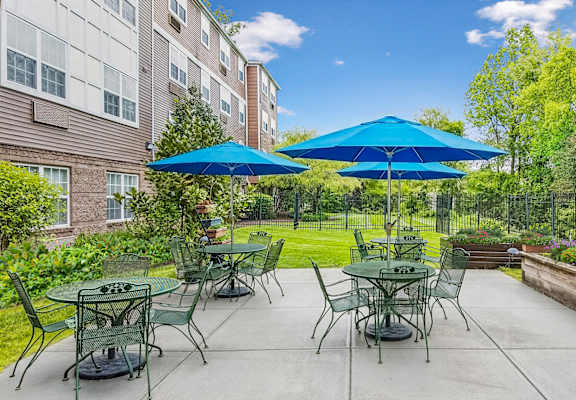 A patio with tables and chairs and umbrellas.