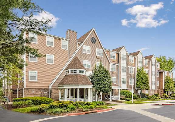 A large apartment complex with a central courtyard and a variety of trees.