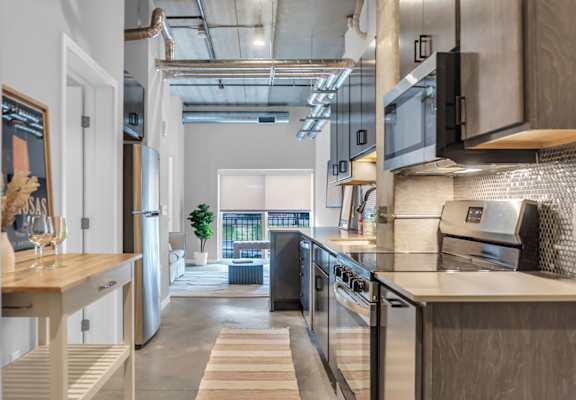 A modern kitchen with a view of the balcony outside.