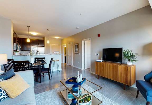 a living room and dining room with a couch and a tv
