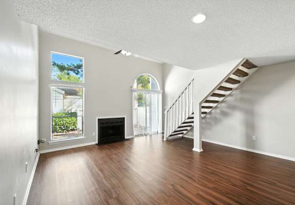 A room with a staircase and a fireplace.