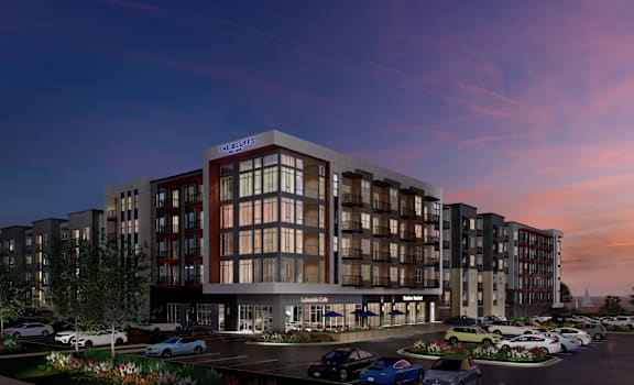 A modern apartment building with a parking lot in front.