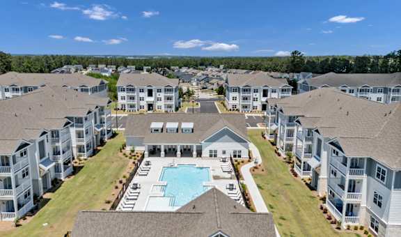 A large apartment complex with a swimming pool in the center.