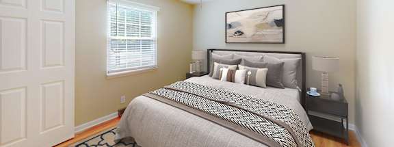 A bedroom with a bed, nightstand, and a ceiling fan.