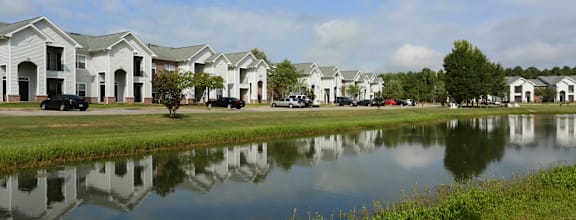 A row of houses are reflected in the water.