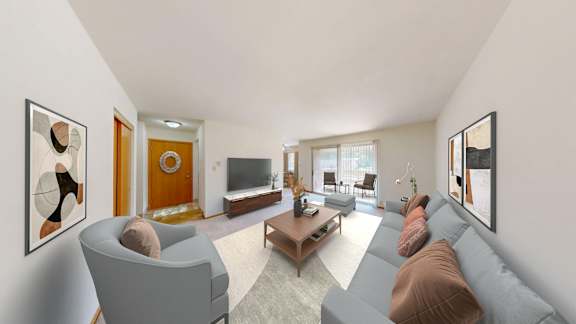 A living room with a grey couch and a brown cushion.