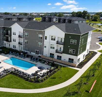 A large apartment complex with a pool in the middle.