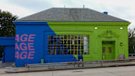 A blue and green building with the words "AGE" and "AGE" on it.