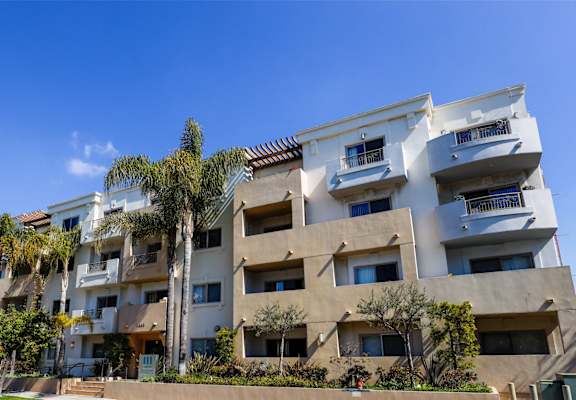 a large apartment building with palm trees in front of it