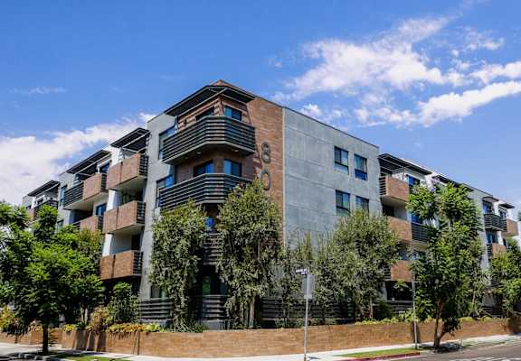 an apartment building on a street corner with trees