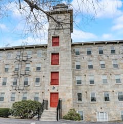 a large stone building with red doors and a tower