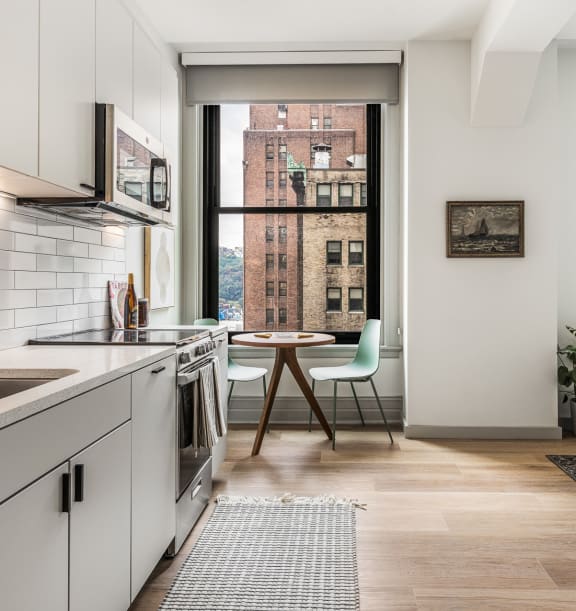 a kitchen with white cabinets and a sink and a window at The Commonwealth Building, Pittsburgh, 15222