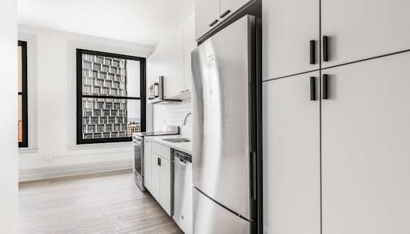 an apartment kitchen with white appliances and a window at The Commonwealth Building, Pittsburgh, 15222