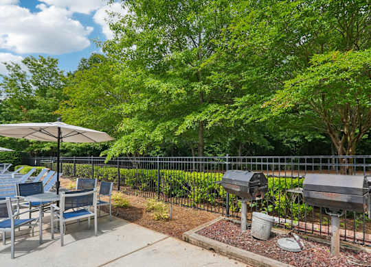 A grill area with a table and chairs.