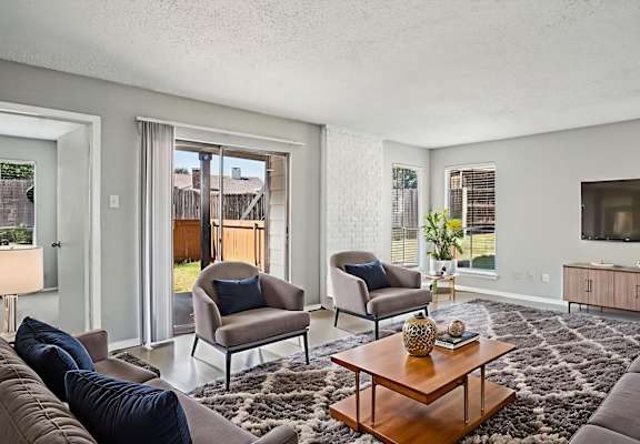 A living room with a brown couch, a coffee table, and a television  at Keller Oaks, Carrollton, TX 75006