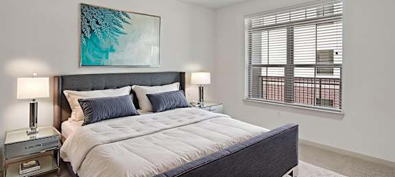 A bedroom with a large bed and a ceiling fan.