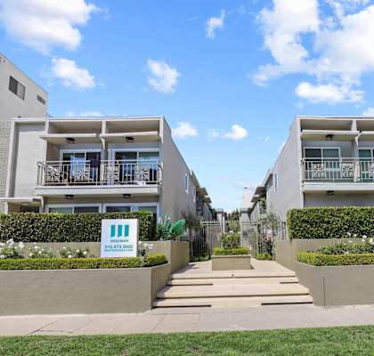 a row of apartments with steps and grass in front of them