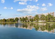 Thumbnail 30 of 33 - A serene lake with a building in the background.