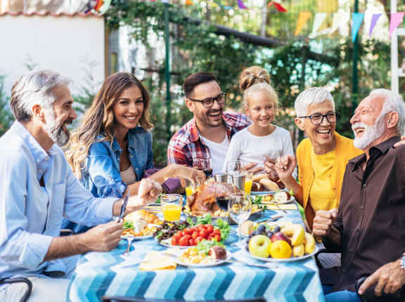 A group of people are gathered around a table enjoying a meal together.