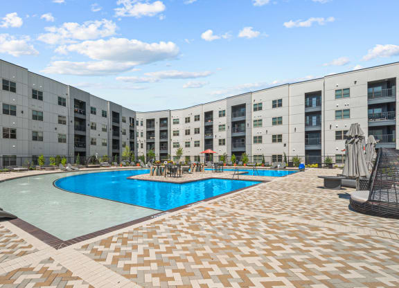 a large swimming pool in front of an apartment building