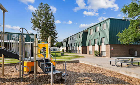 a playground at a school with a building in the background