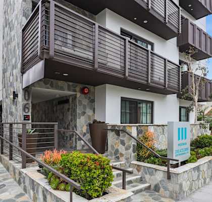a building with a porch and a sidewalk in front of it