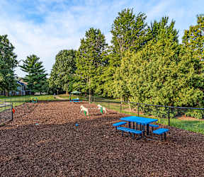 A playground with a red slide and a blue picnic table.