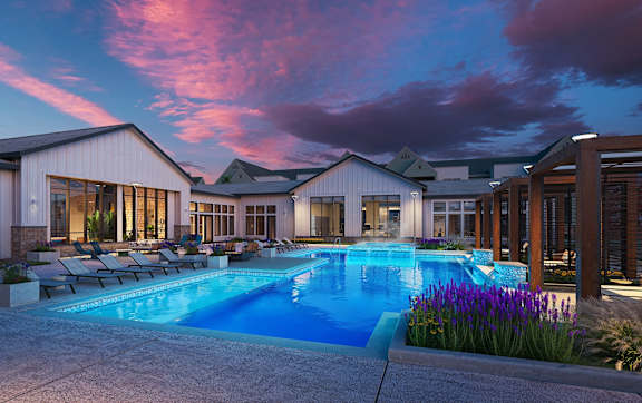 A large house with a swimming pool in front.