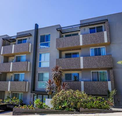 a large apartment building with a blue sky in the background