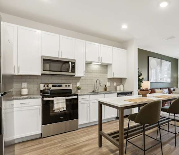 A modern kitchen with a dining table and chairs.