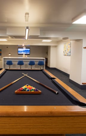 A pool table in a room with bookshelves and a TV. at The Argonne Apartments, Washington, DC, 20009