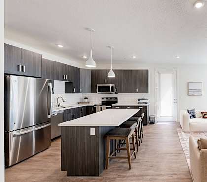 A modern kitchen with a long island and bar stools.