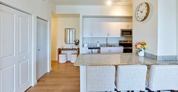 A kitchen with a table and chairs in front of it.