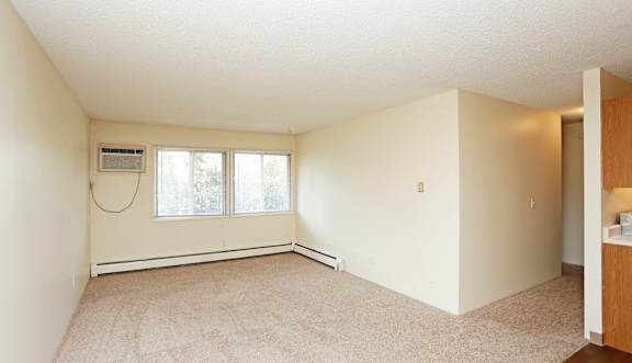 A room with a window and a carpet on the floor.at Foxwood Apartments, Indianola Iowa