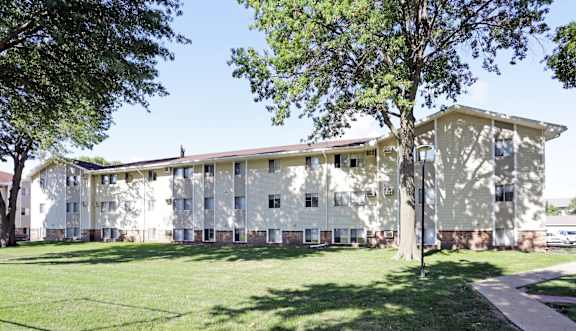 A large building with a green lawn in front.at Foxwood Apartments, Indianola, 50125